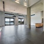 Interior of spacious new minimalist house with wooden furniture and panoramic windows with amazing lake view